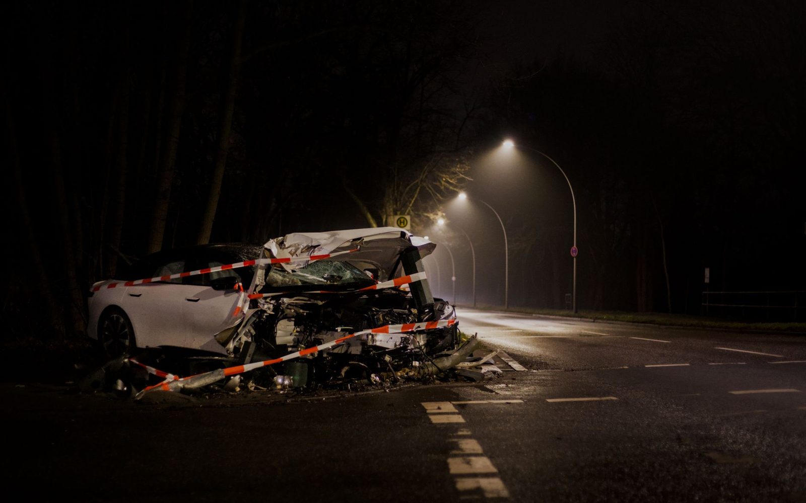 Automóvil destrozado en una calle poco iluminada durante la noche.