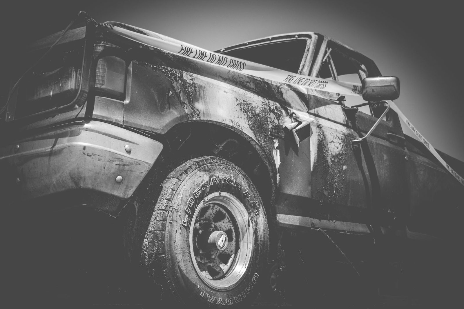 Camión dañado tras una cinta de la policía, en una foto en blanco y negro.