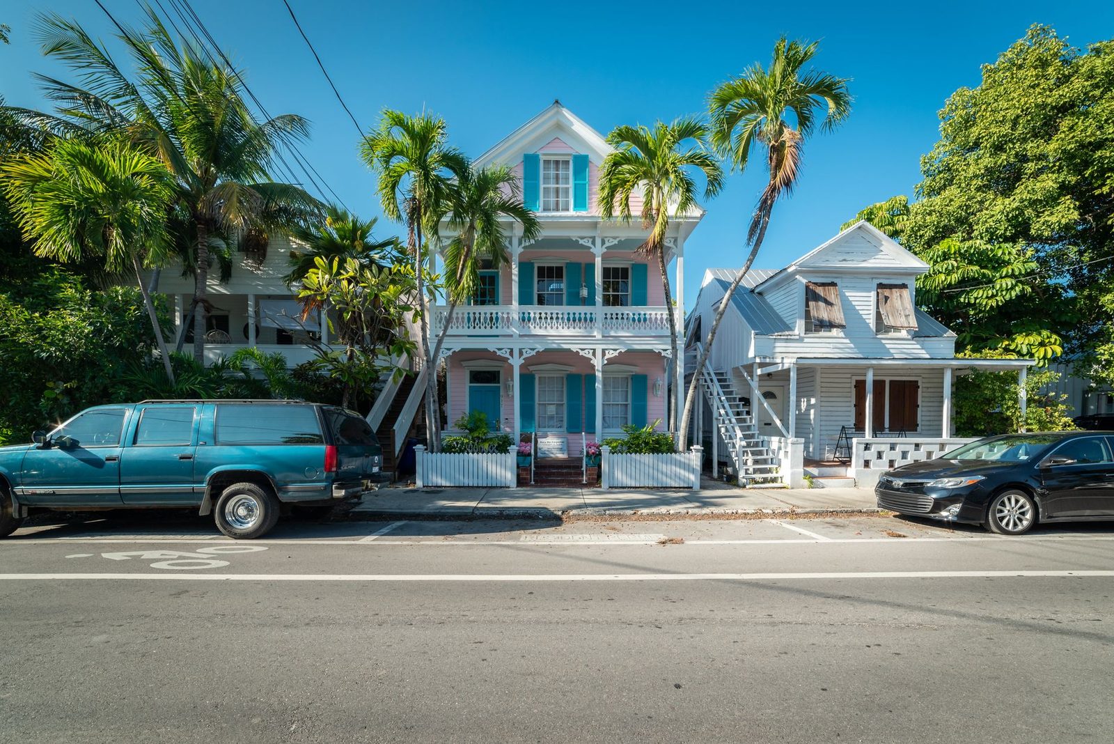 Casas históricas coloridas con palmeras en calle soleada de Key West, Florida.