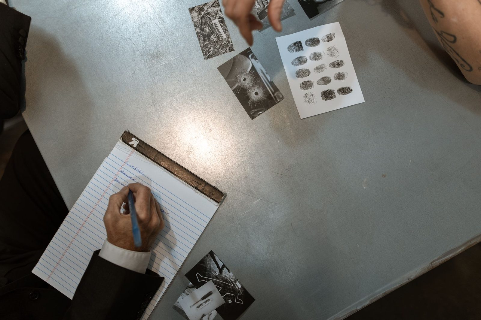 Police officers reviewing evidence and taking notes during an investigation.