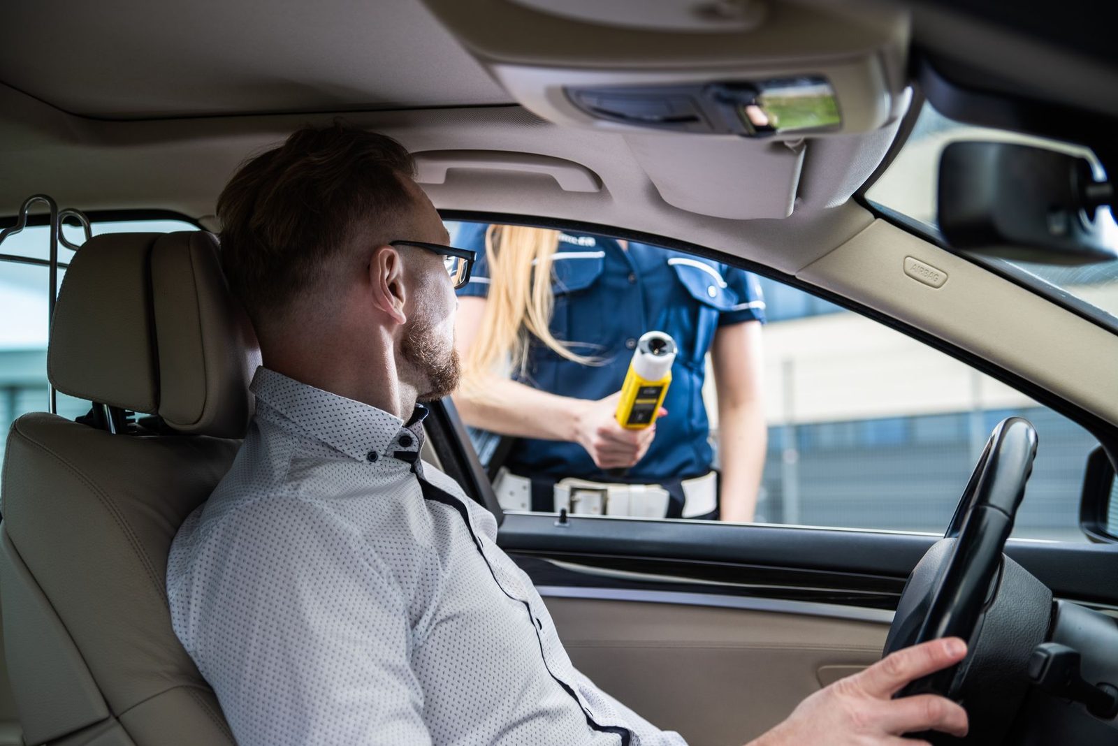 A police officer gives a breathalyzer test to a driver during a roadside sobriety check.