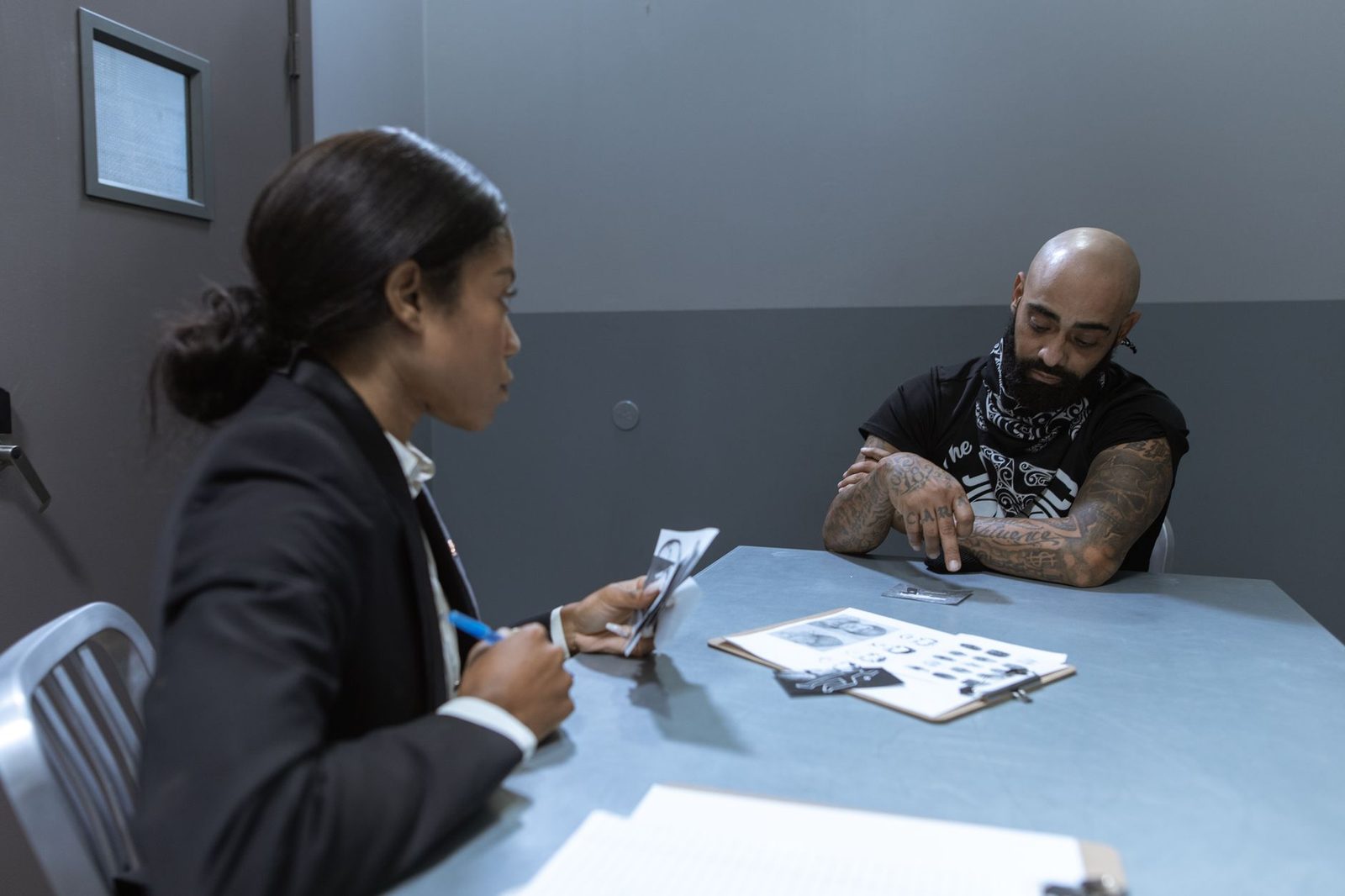 Police officer reviewing case documents and evidence during an investigation interview.