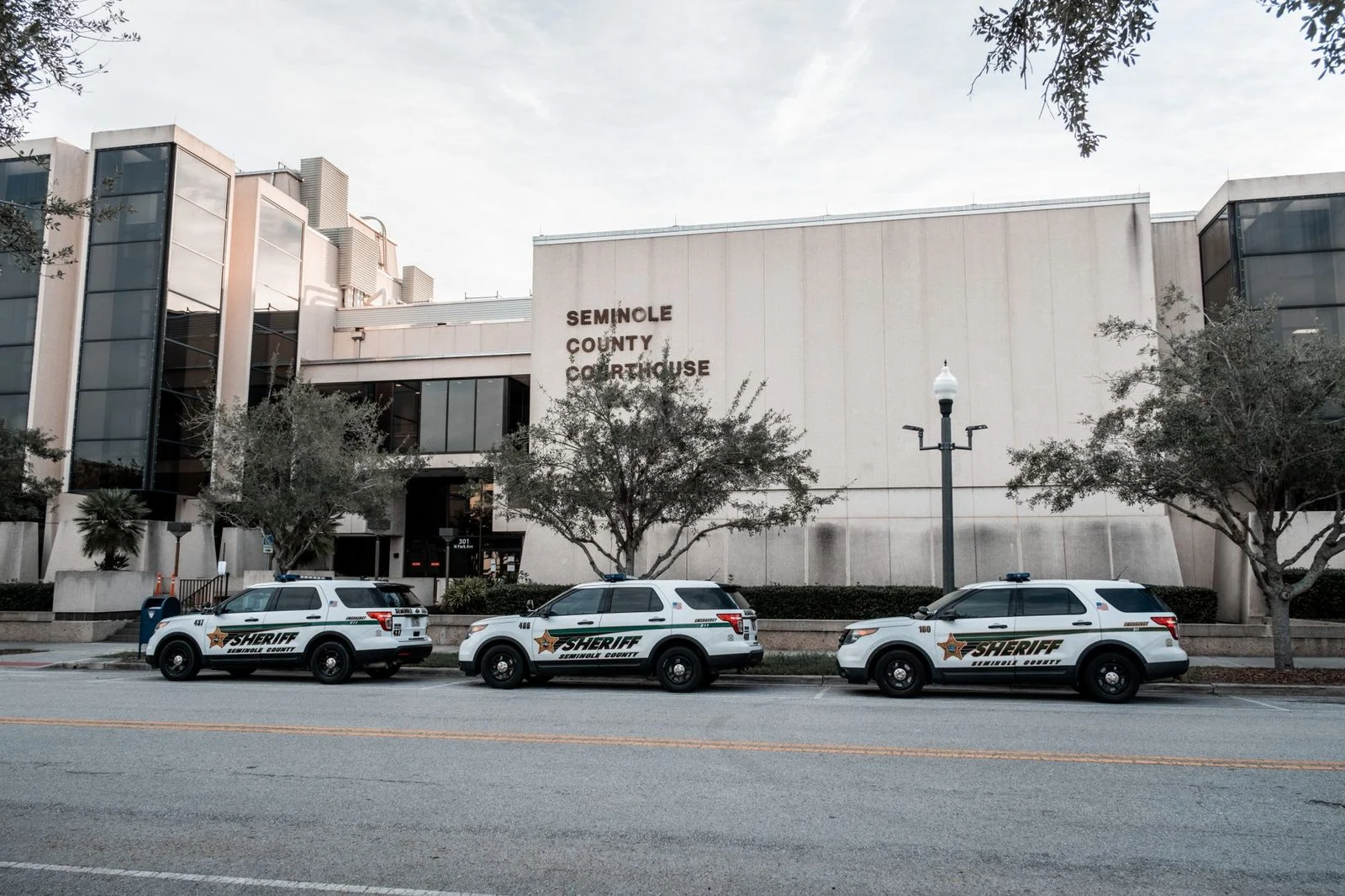Sheriff vehicles parked in front of the Seminole County Courthouse during daytime.