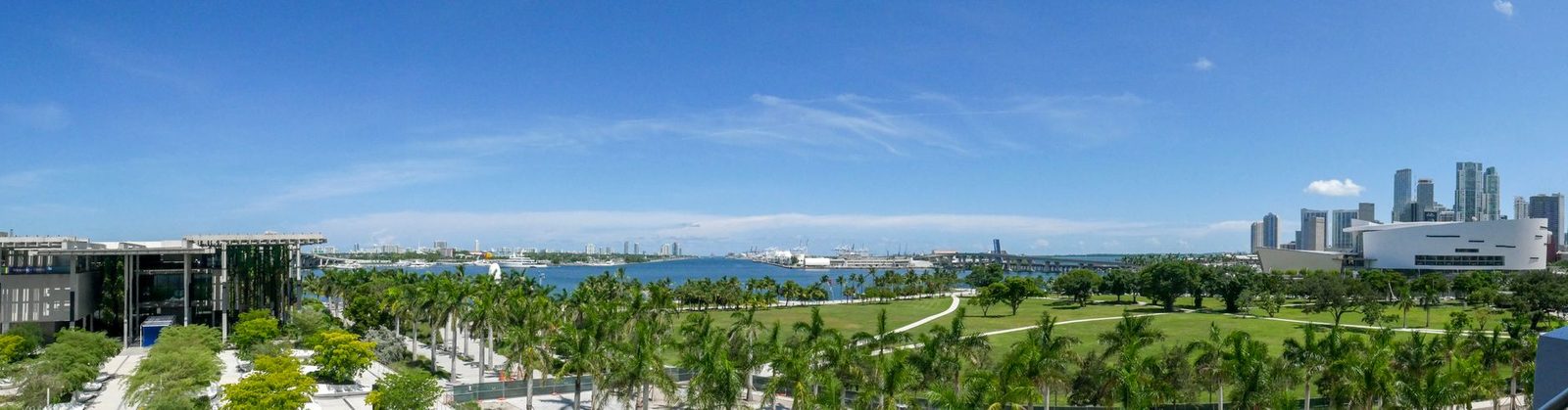 Skyline de Miami con parques verdes y cielo azul claro.