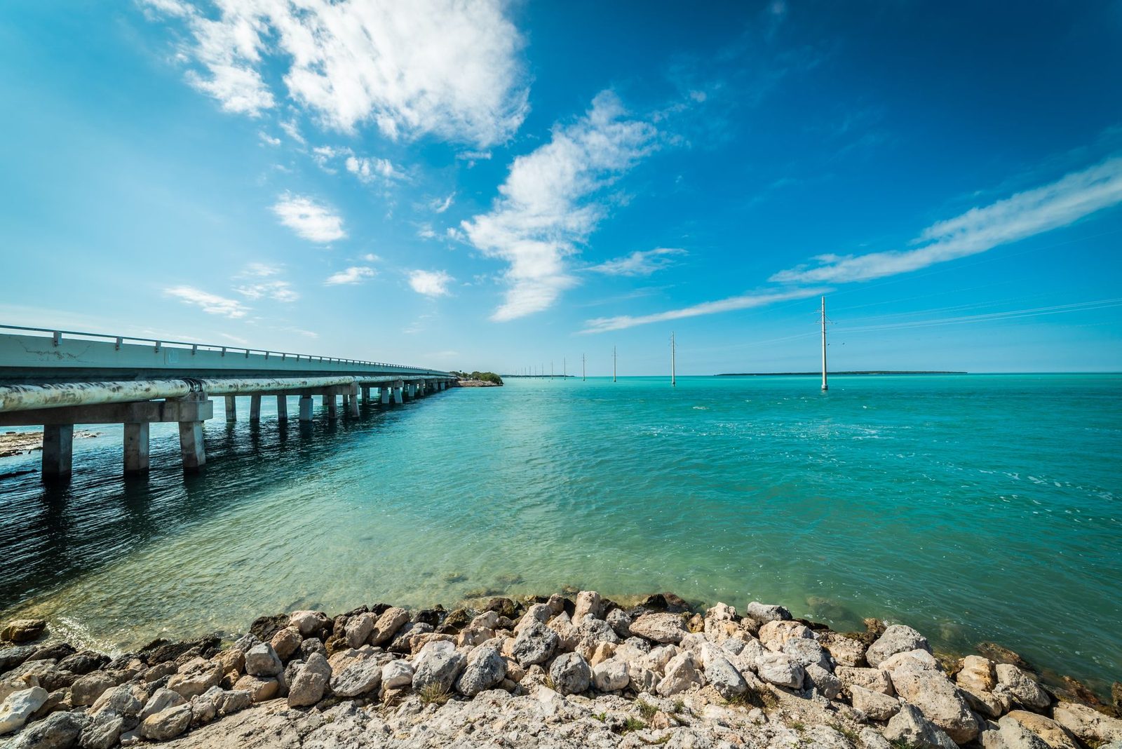 Vista del océano en los Cayos de Florida con puente bajo cielo azul despejado.
